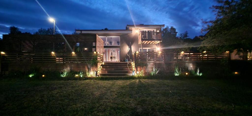 una casa con luces en el patio por la noche en Stilren svit lägenhet med trädäck och laddstation, en Motala