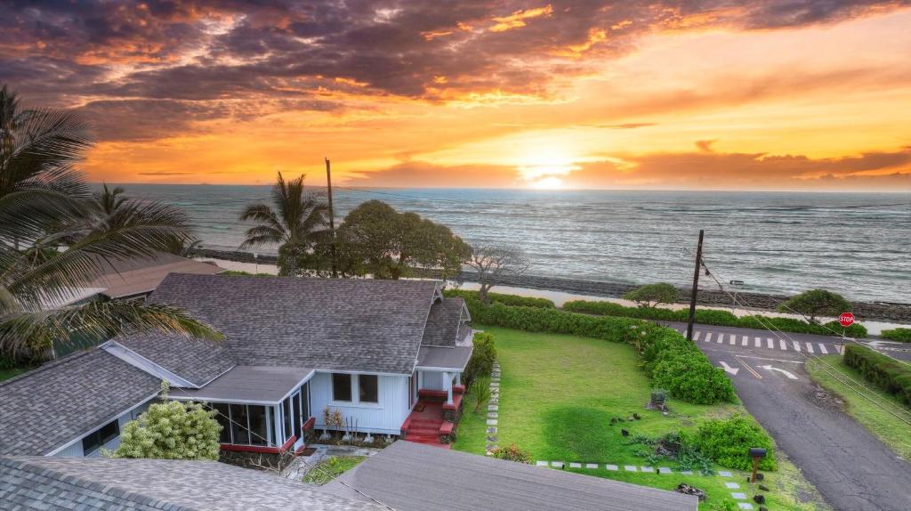 a house with a view of the ocean at sunset at OceanFront Kauai - Harmony TVNC 4247 in Kapaa