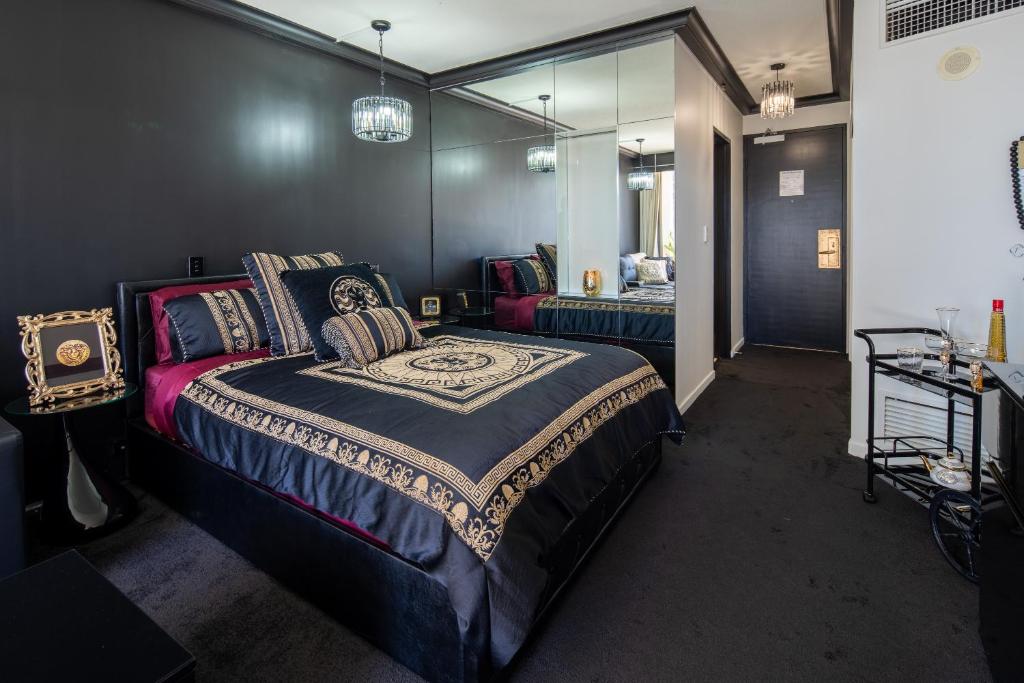a bedroom with a large bed and a mirror at Designer Suites - Versace On View in Gold Coast