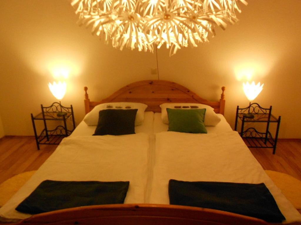 ein Schlafzimmer mit einem großen Bett mit einem Kronleuchter in der Unterkunft Tannhäuser Ferienwohnung in Bad Dürrheim