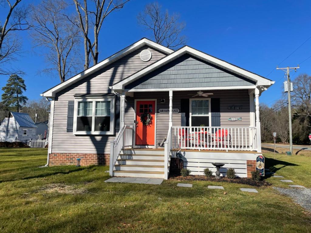 a small white house with a red door at Our Happy Place in Colonial Beach in Colonial Beach