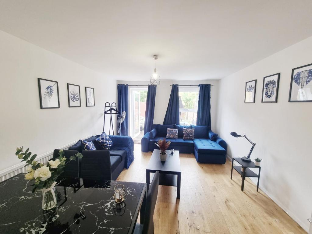 a living room with a blue couch and a table at Underwood at Shoreditch in London