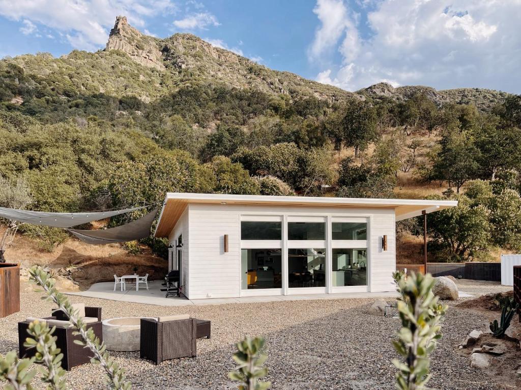 a small white house with a mountain in the background at Eagle Rock Nest ～Quiet & Gorgeous Mountain Views in Three Rivers