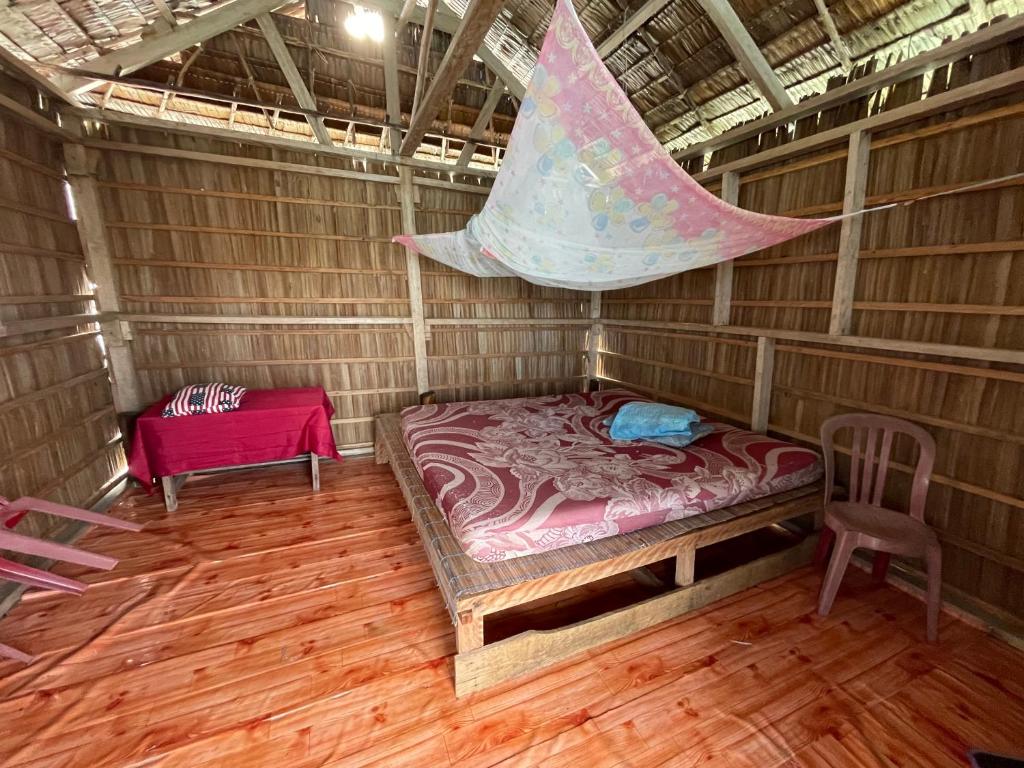 a room with a bed and a net in it at Kri guest homestay in Rancakole