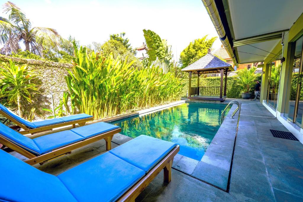 a swimming pool with two lounge chairs and a gazebo at Villa LOGAN - KUTA - 5 Bedroom - 3 Bathroom Villa - Great Location in Kuta