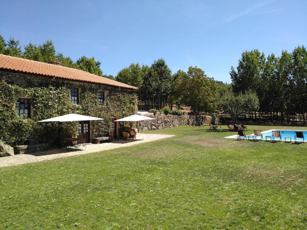 een gebouw met een tuin met een zwembad en tafels bij Douro Villa with Private Pool in Armamar