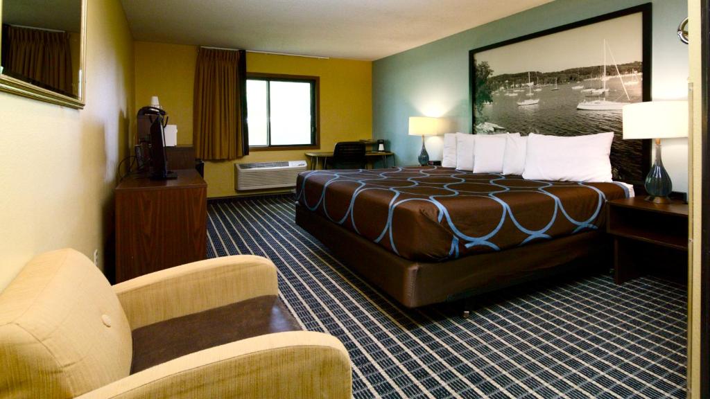 a hotel room with a bed and a couch at Super 8 by Wyndham Red Wing in Red Wing