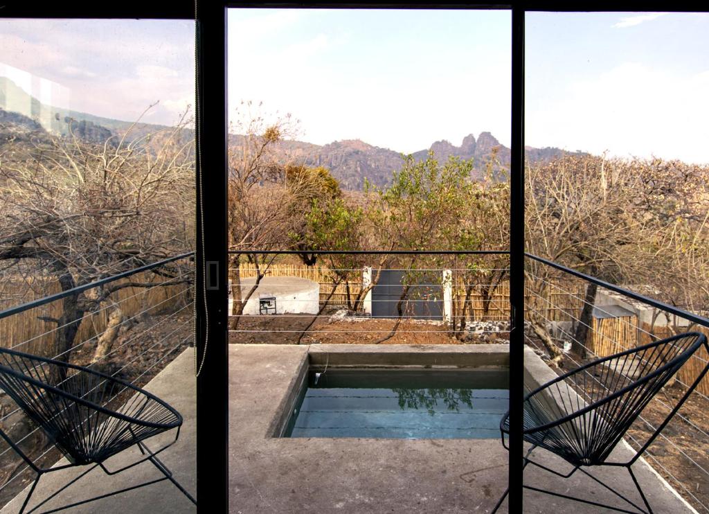 uma vista a partir da varanda de uma casa com piscina em Piedra de Cobre em Tepoztlán