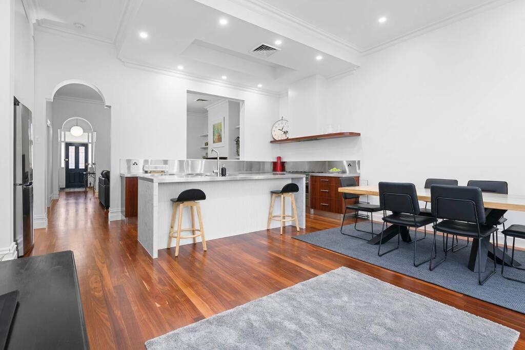 a kitchen and living room with a table and chairs at Ballantyne Abode in Thebarton