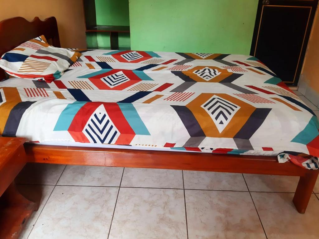 a bed with a colorful comforter on top of it at Residencial RM in Puerto Francisco de Orellana