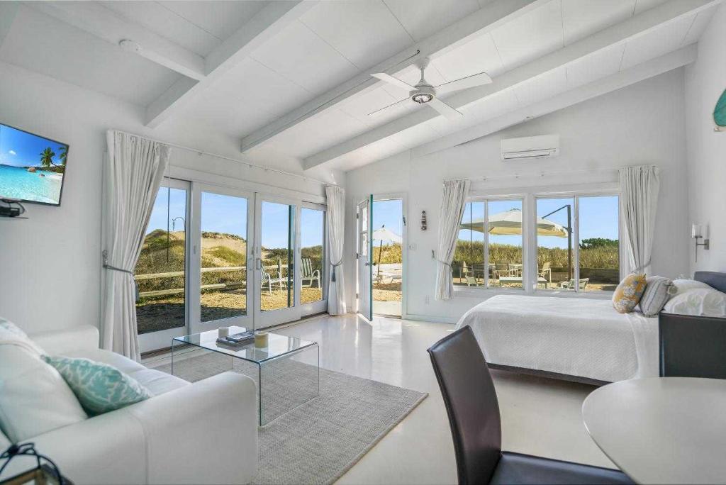 a bedroom with a bed and a couch and a table at Driftwood Resort on the Ocean in Montauk