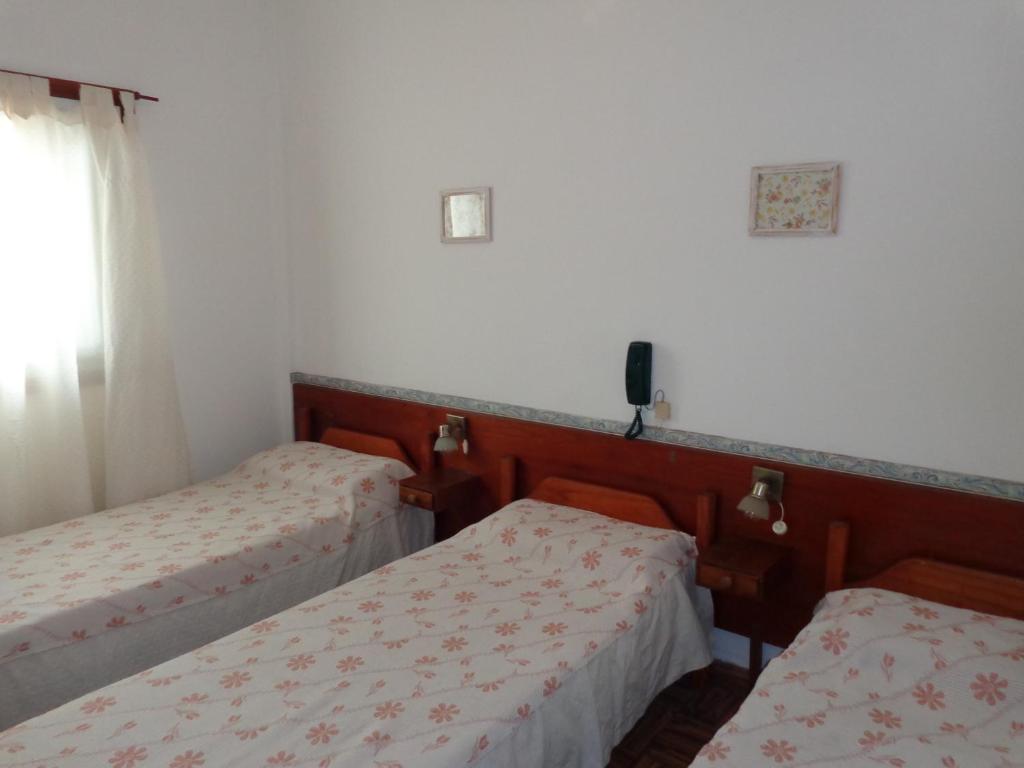 2 camas en una habitación con paredes blancas en Las Heras Hotel en Mar del Plata