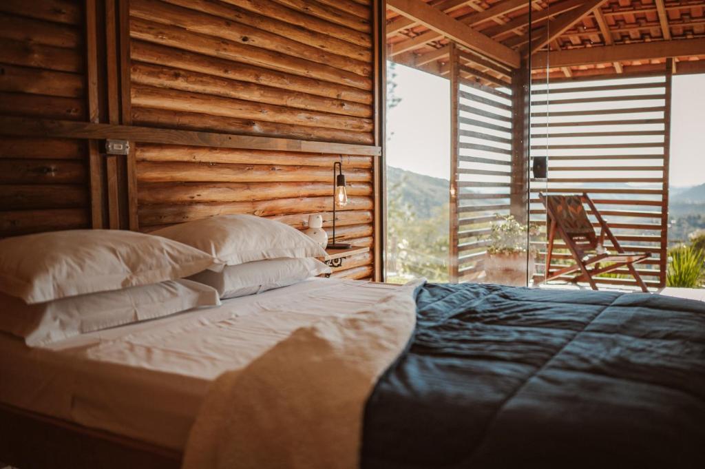 1 dormitorio con 1 cama frente a una ventana en Chalé do Vale locação de temporada, en Águas de Lindóia