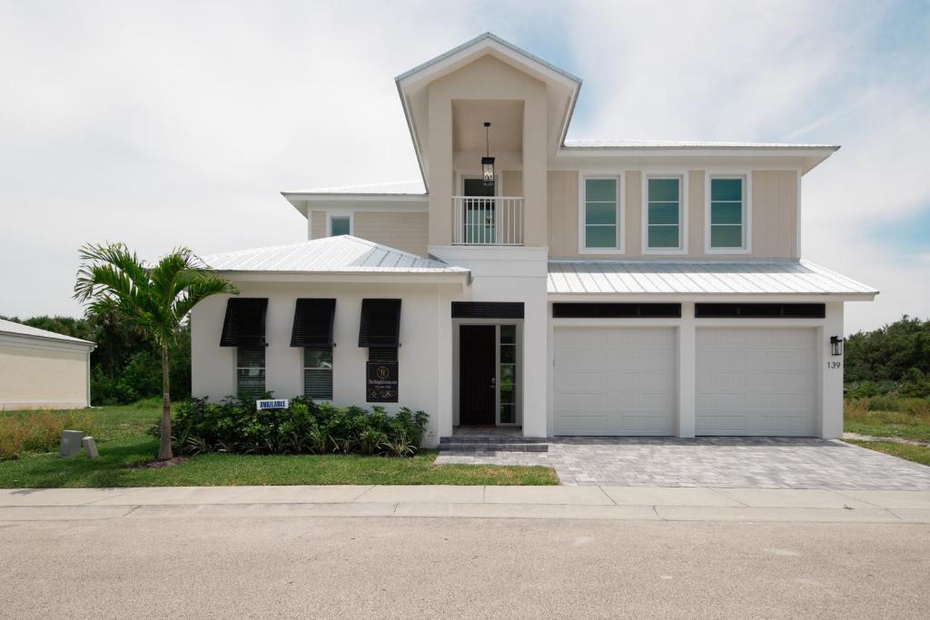 a white house with two garage doors at Ocean Estate in Fort Pierce