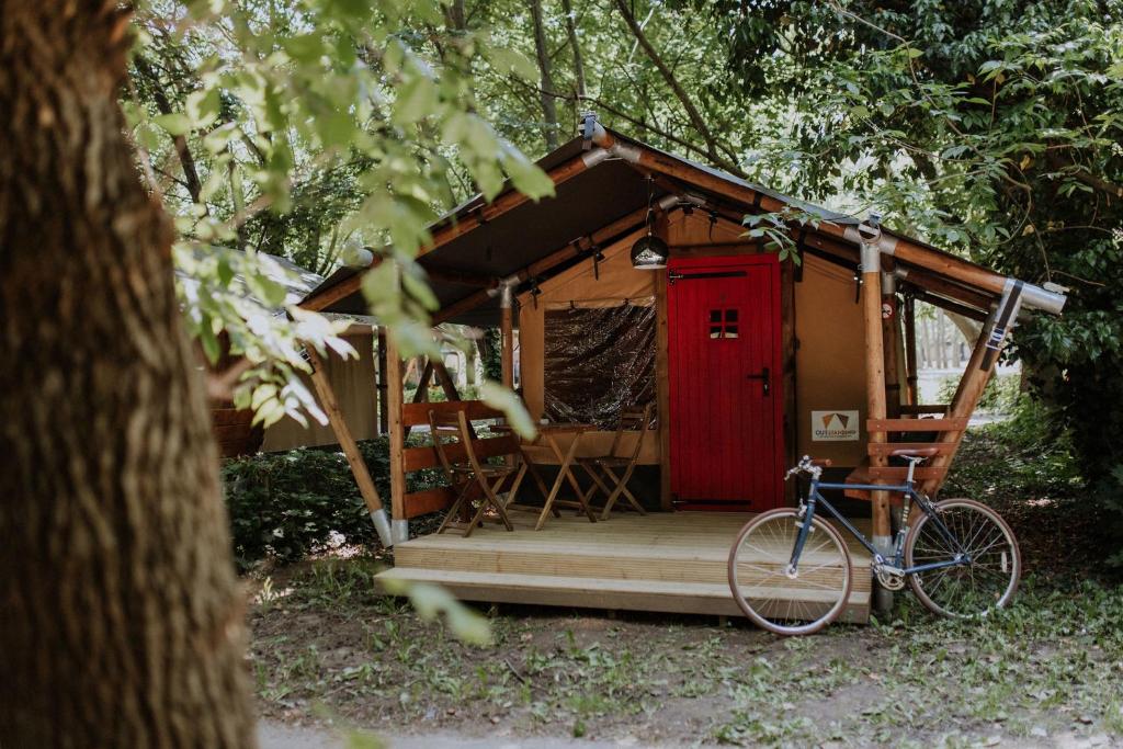 a bike parked in front of a house with a red door at Sioglamping in Siocamping in Siófok