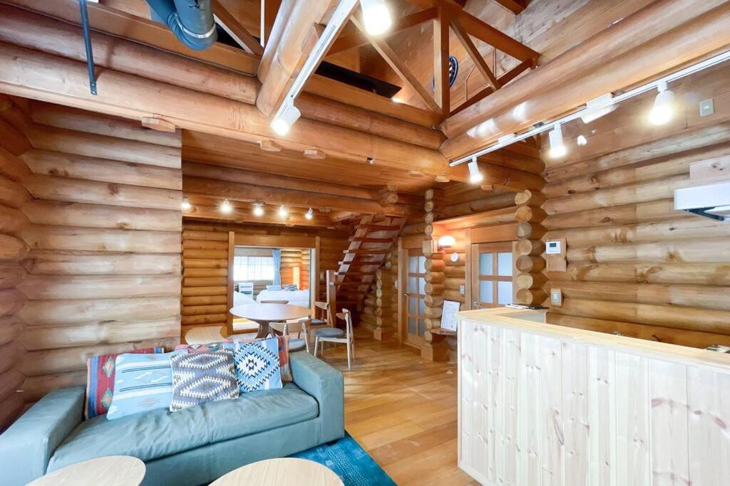 een woonkamer met een bank in een blokhut bij S-villa Karuizawa - the forest - in Kita-karuizawa