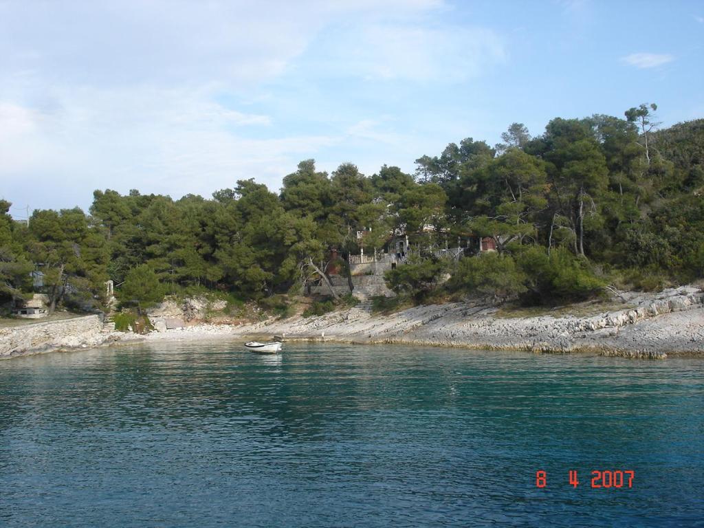 a boat in the water next to a beach at Villa Terra Nostra Hvar in Hvar