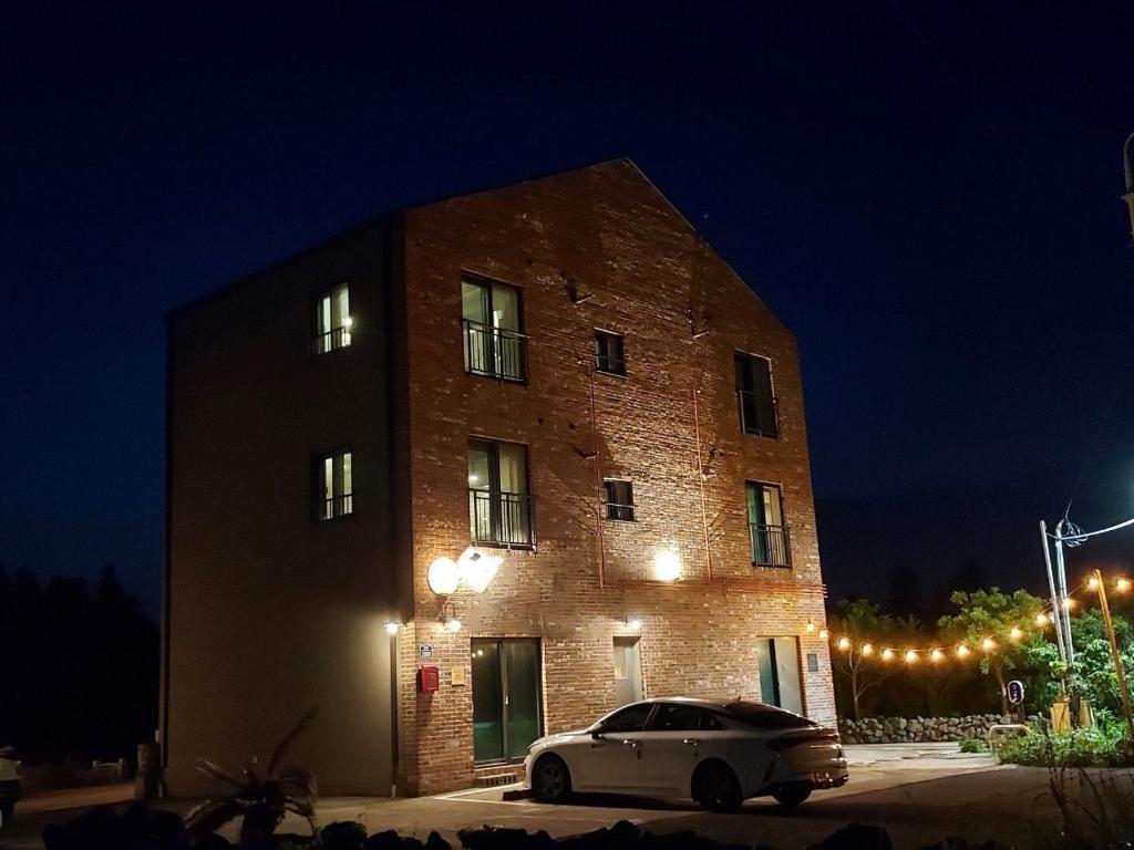 a car parked in front of a brick building at night at Soo Stay in Seogwipo