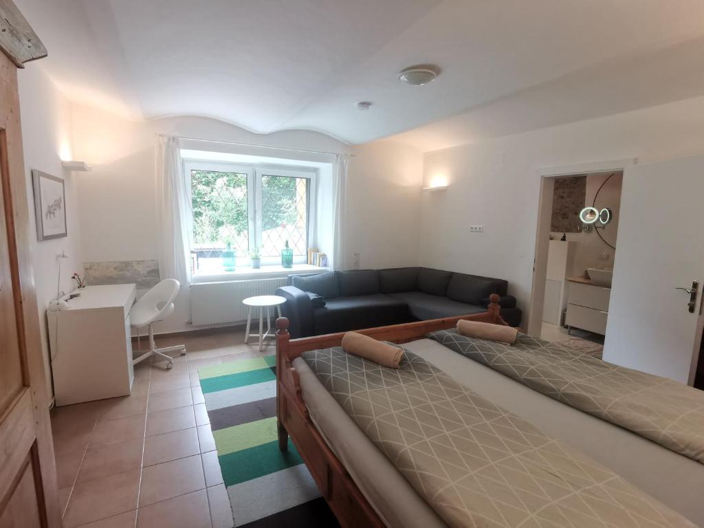 salon z dwoma łóżkami i kanapą w obiekcie Ruhe am Wald - zentral und Wörthersee w mieście Klagenfurt