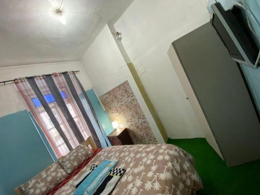 um pequeno quarto com uma cama e uma janela em Lisbon Bangla em Lisboa