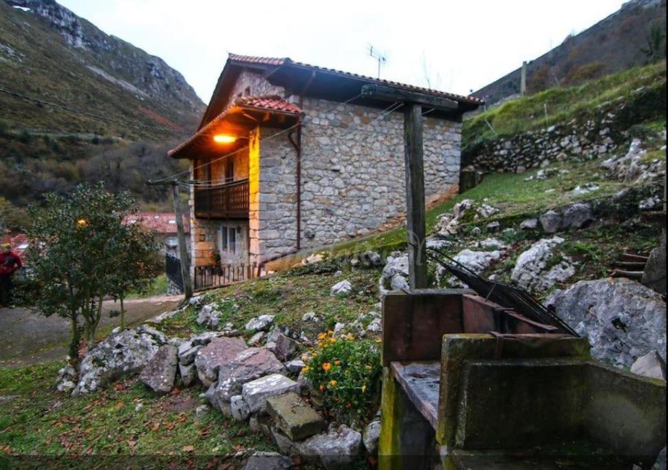a stone building with a light on the side of a mountain at Alojamiento Rural Casa La Mata. in Cuñaba