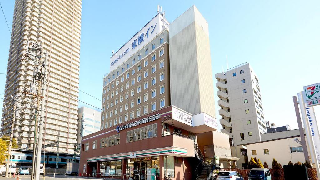 un edificio in una strada di città con edifici alti di Toyoko Inn Yokohama Shinkoyasu Ekimae a Yokohama