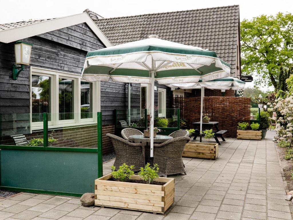 une terrasse avec une table et un parasol dans l'établissement Charming house with garden in rural area Hellendoorn, à Hellendoorn