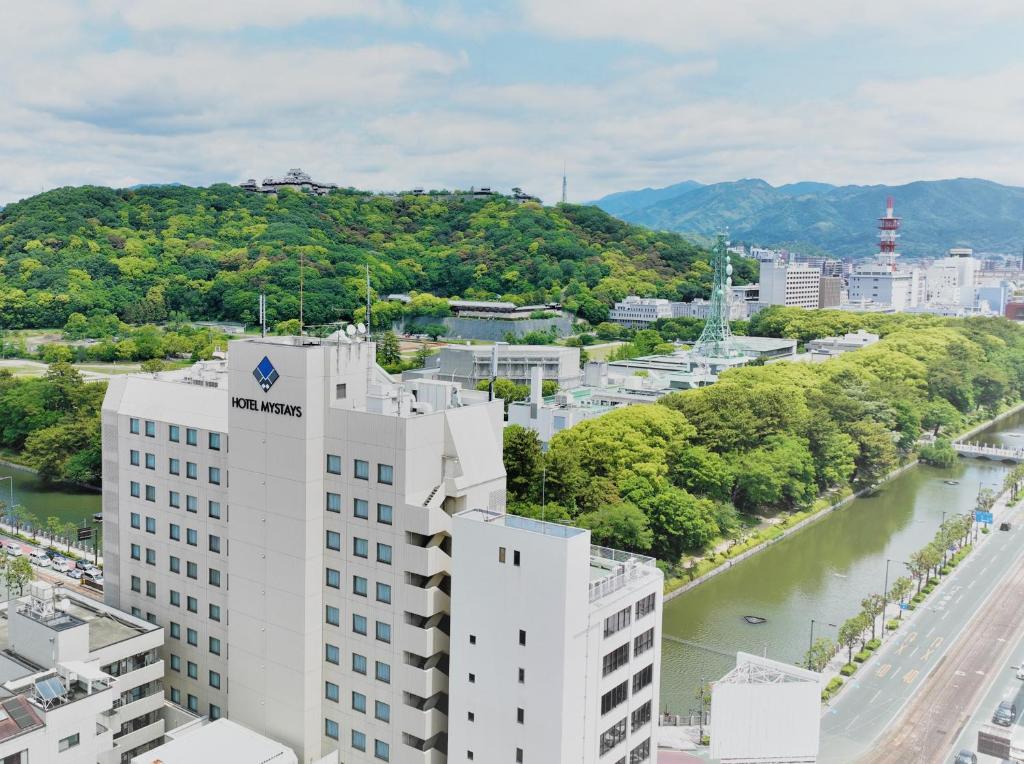 an aerial view of a building and a river at HOTEL MYSTAYS Matsuyama in Matsuyama