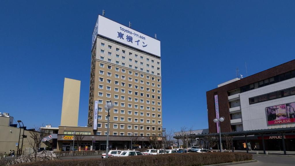 Un grand bâtiment avec un panneau en haut dans l'établissement Toyoko Inn Hirosaki Ekimae, à Hirosaki