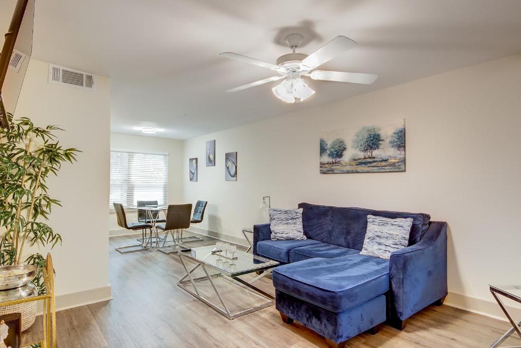 a living room with a blue couch and a ceiling fan at Downtown Atlanta’s hidden gem! in Atlanta