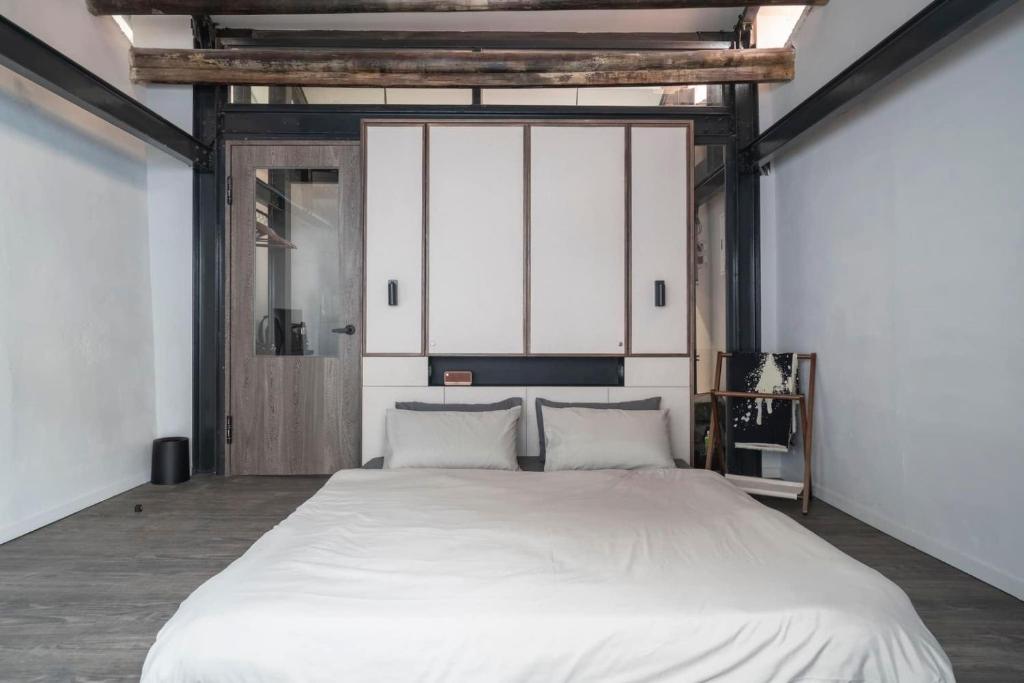 ein Schlafzimmer mit einem großen weißen Bett mit zwei Kissen in der Unterkunft Sukinab&b喜歡旅居曲巷冬晴 in Lukang
