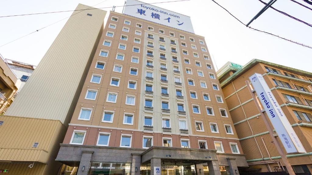 热海热海站前东横旅馆(Toyoko Inn Atami Ekimae) 的一座高楼，楼顶有标志