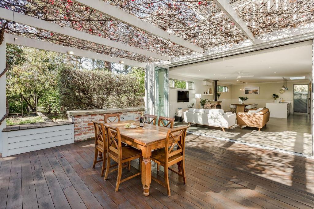 Un patio al aire libre con una mesa y sillas de madera. en Beach Life on Beach, en Dunsborough