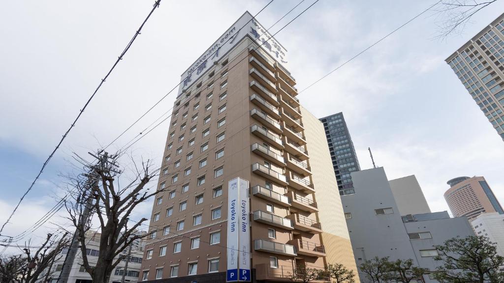 a tall building in a city with tall buildings at Toyoko Inn Hamamatsu eki Kita guchi in Hamamatsu