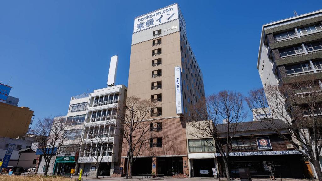 a tall building with a clock on top of it at Toyoko Inn Shimonoseki Kaikyo yume tower Mae in Shimonoseki