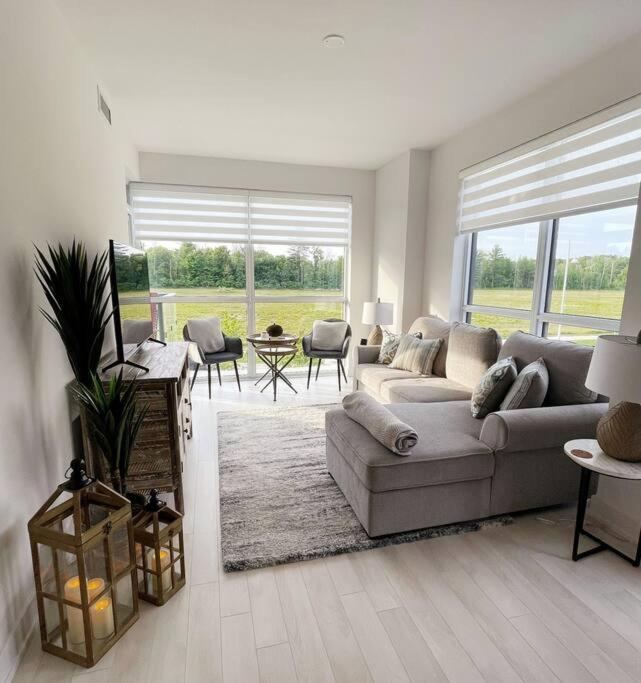 a living room with a couch and a large window at 2 bedroom 2 bath Aquarius, Friday Harbour, Innisfil, Barrie in Innisfil