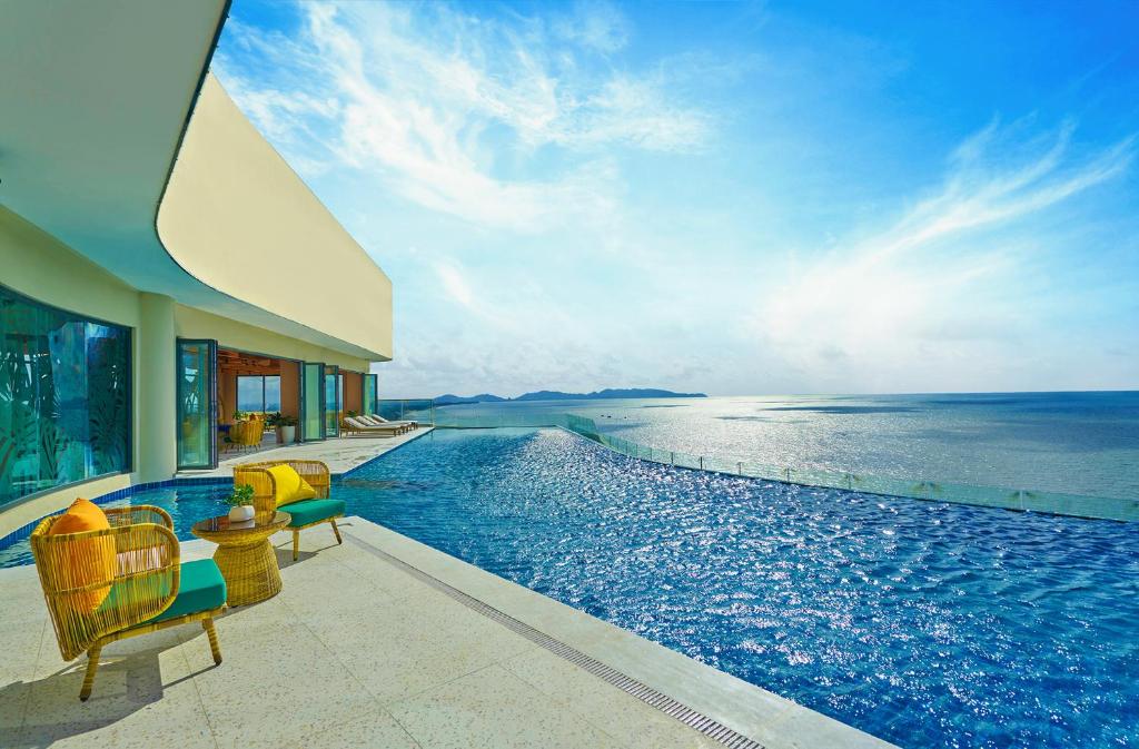a swimming pool with chairs and a view of the ocean at Vias Hotel Vung Tau - Inclusive Transportation in Vung Tau