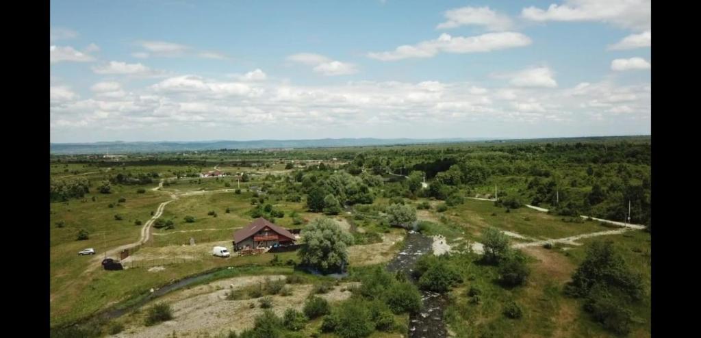une vue aérienne sur une maison dans un champ dans l'établissement La Văru, à Cârţişoara