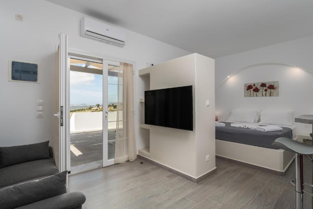 a bedroom with a bed and a tv and a couch at Sunset Village 4 in Paleochori