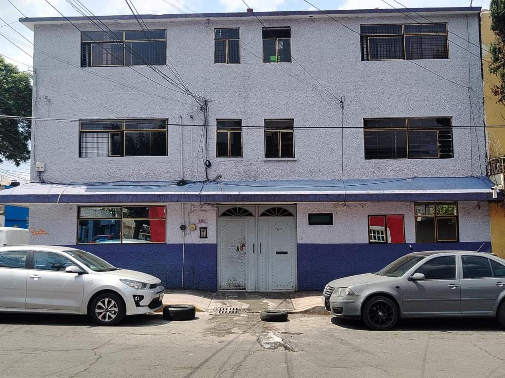 dos coches estacionados frente a un edificio en Alojamiento Morelos, en Ciudad de México