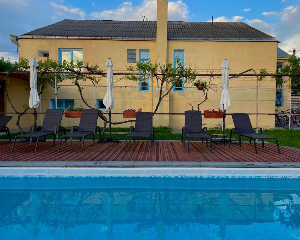 a group of chairs and umbrellas next to a pool at Brewery House&Beer Spa in Aspindza