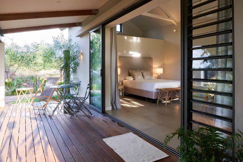 Pokój z łóżkiem i balkonem z sypialnią w obiekcie Peaceful Tree Cottage w mieście Tamarin