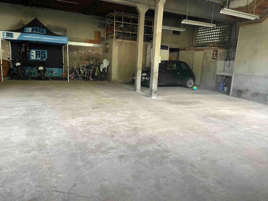 a parking lot with a car parked in a garage at Manornella, beaux volumes, grand garage idéal Mas du Clos in Aubusson