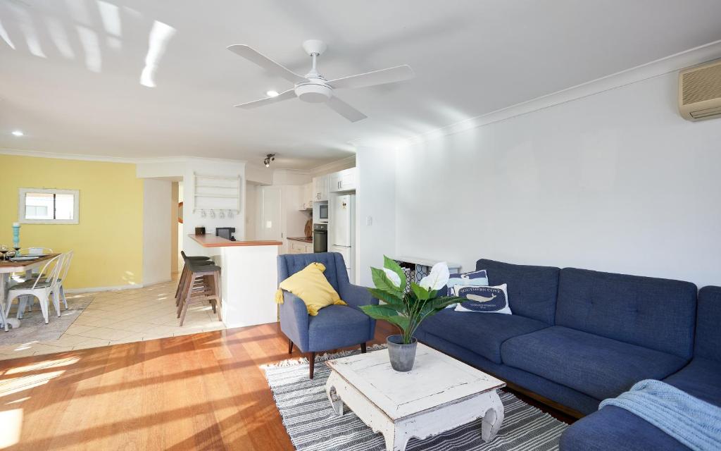 sala de estar con sofá azul y mesa en Large, Light, dog friendly home 600m to Burleigh beach en Gold Coast