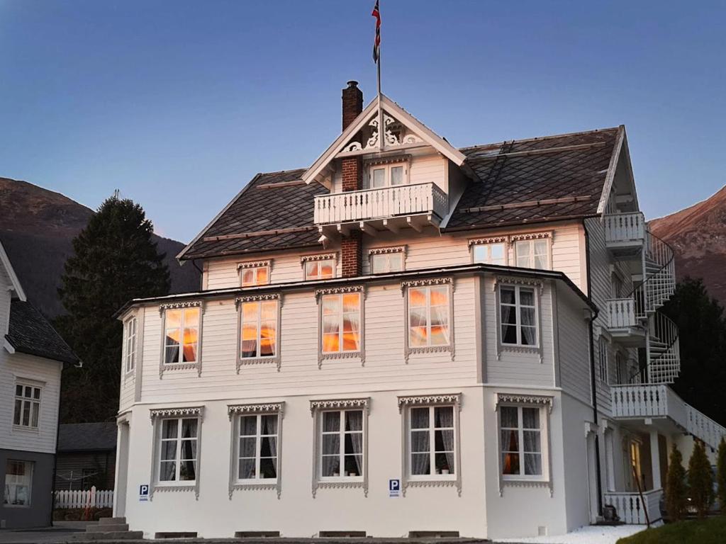 a white house with a balcony on top of it at Sylte Hotell, Valldal in Valldal