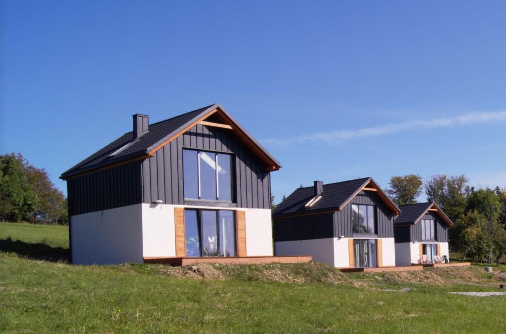 een rij huizen op een heuvel in een veld bij Domki Blisko Nieba III in Wisła