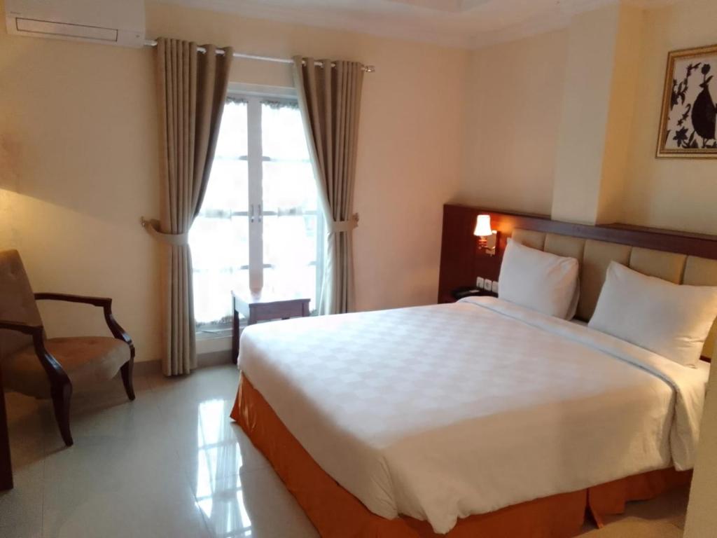 a bedroom with a large bed and a window at LE SEMAR HOTEL KARAWACI in Dahung