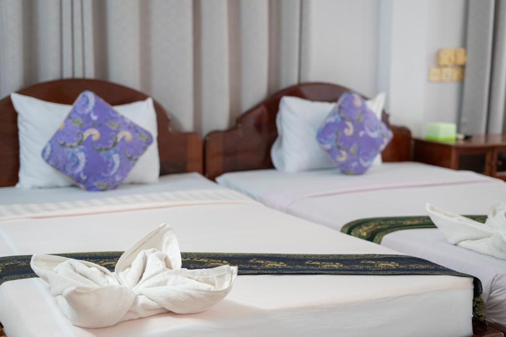 Postel nebo postele na pokoji v ubytování Siem Reap Riverside Hotel