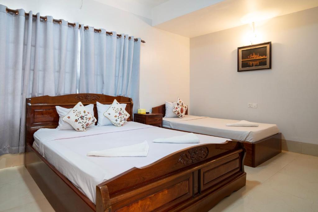 Postel nebo postele na pokoji v ubytování Siem Reap Riverside Hotel