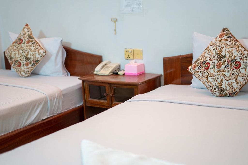 Postel nebo postele na pokoji v ubytování Siem Reap Riverside Hotel